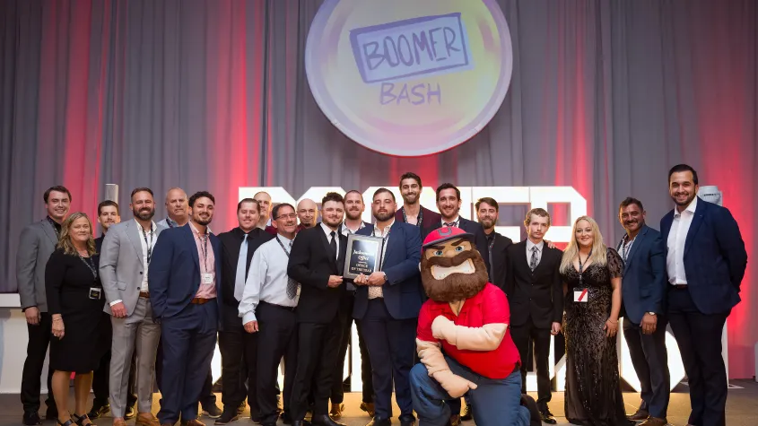 An event photo of an awards ceremony with a large group of people on stage.