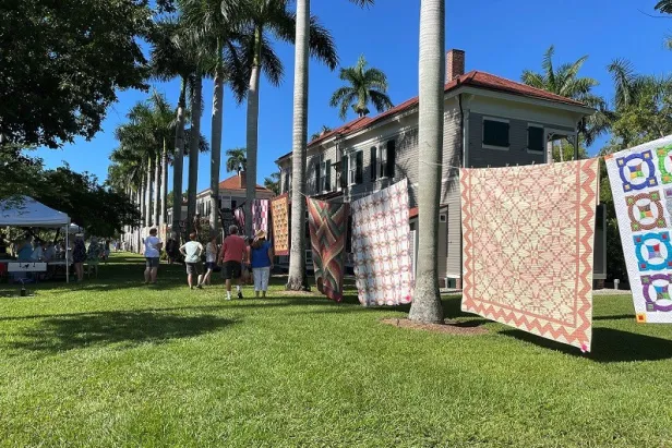 quilts hanging along historic homes
