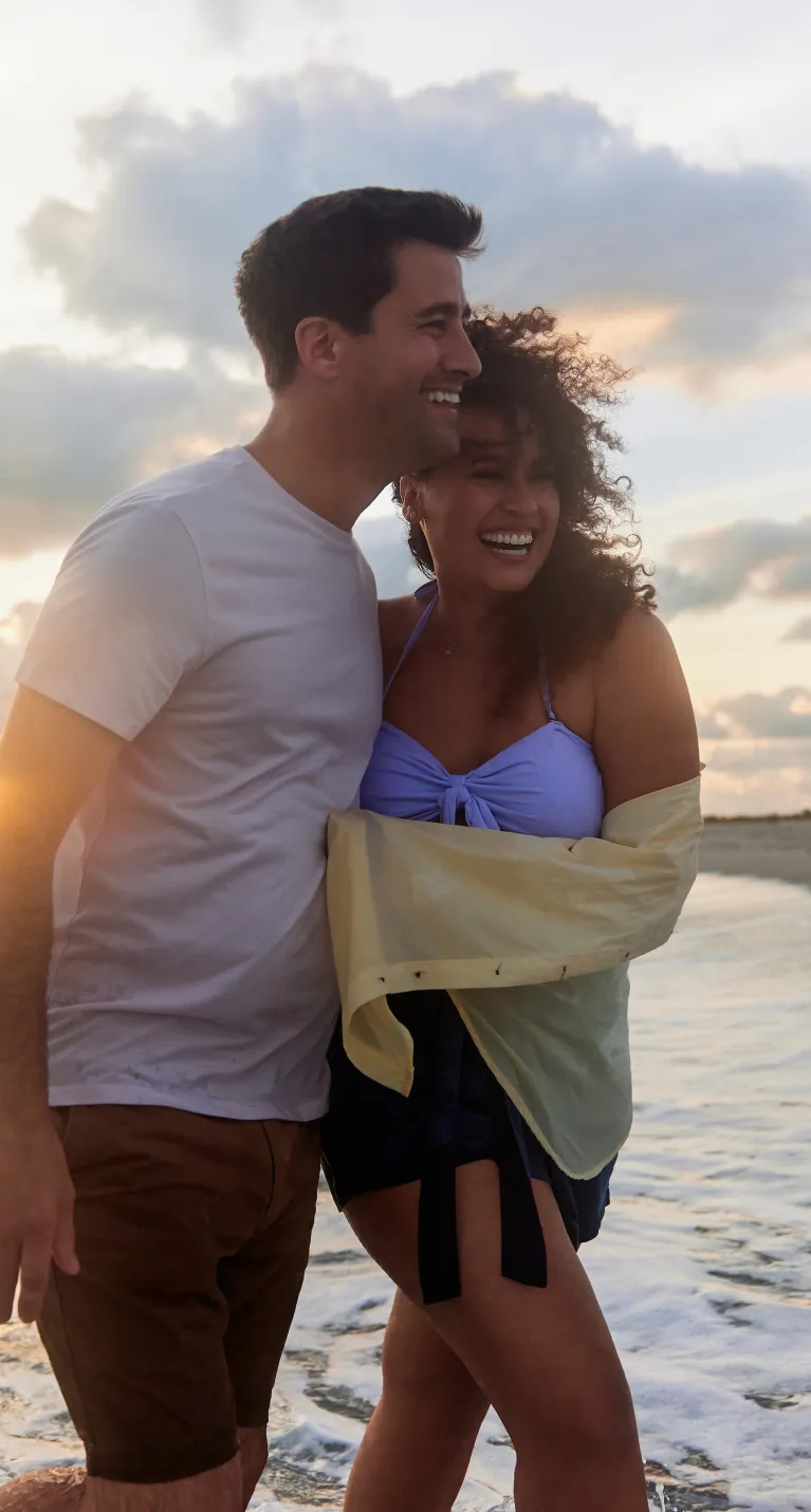 A couple enjoys sharing a sunset on a secluded beach
