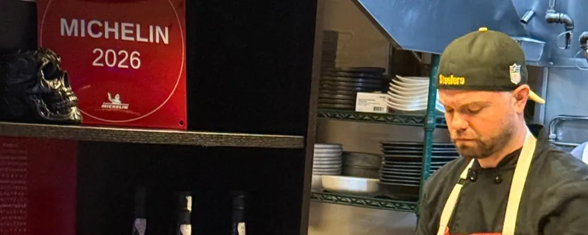 The chef cooks at Liberty restaurant and the MICHELIN plaque sits nearby on the shelf