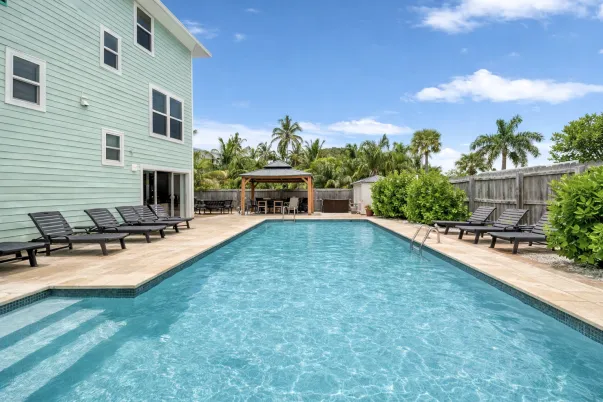 Southern Serenity FMB vacation rental with private heated pool, lounge chairs, and tropical outdoor living space on Fort Myers Beach.