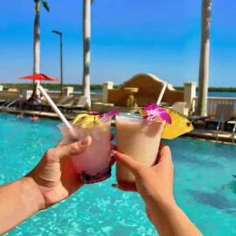 Friends toast at a beach resort pool
